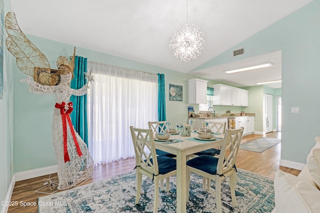 dining area featuring a chandelier, light wood-type flooring, and visible vents