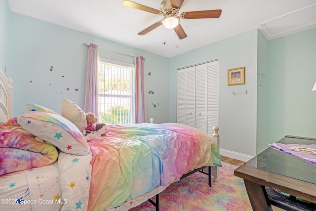 bedroom with baseboards, a ceiling fan, wood finished floors, and a closet