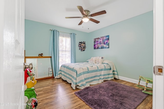 bedroom with wood finished floors, baseboards, and ceiling fan