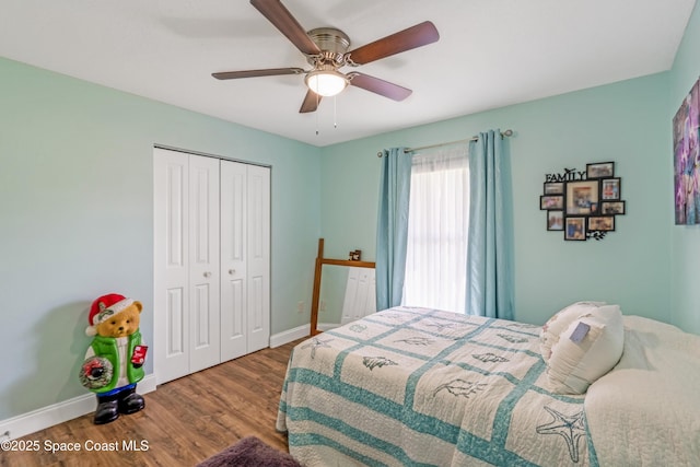 bedroom featuring wood finished floors, a closet, baseboards, and ceiling fan