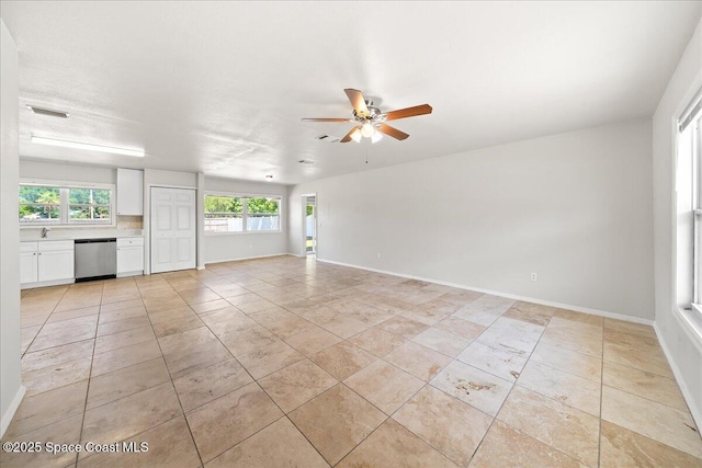 unfurnished living room with a ceiling fan, baseboards, and light tile patterned flooring