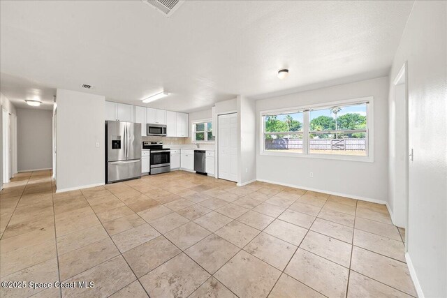 unfurnished living room with baseboards and light tile patterned flooring