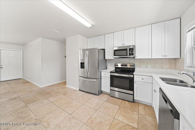 kitchen featuring appliances with stainless steel finishes, a sink, decorative backsplash, and light countertops