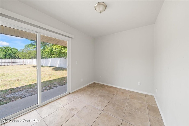empty room featuring light tile patterned floors and baseboards