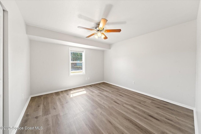 unfurnished room featuring wood finished floors, a ceiling fan, and baseboards