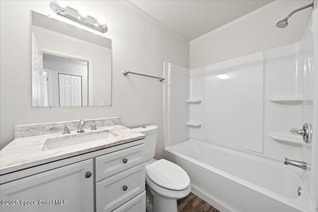 bathroom featuring ornamental molding, toilet, vanity, wood finished floors, and shower / bath combination