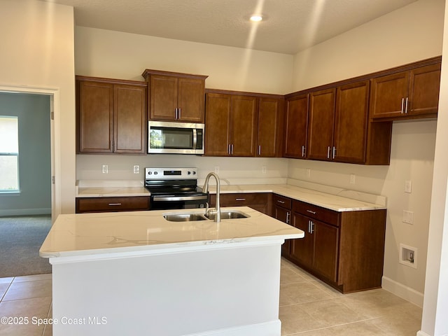 1208 Soleway Ave NW, Palm Bay, FL 32907 - kitchen featuring appliances with stainless steel finishes, light stone counters, light tile patterned flooring, and an island with sink