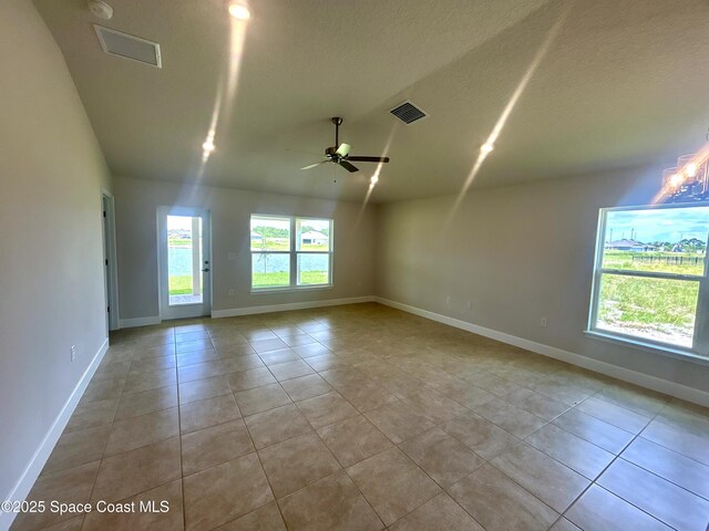 1208 Soleway Ave NW, Palm Bay, FL 32907 - empty room featuring tile patterned floors, vaulted ceiling, ceiling fan, and a textured ceiling