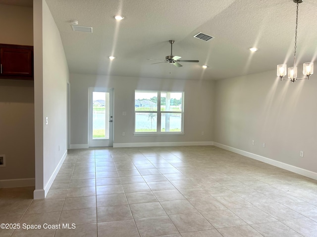 1208 Soleway Ave NW, Palm Bay, FL 32907 - spare room with a ceiling fan, vaulted ceiling, a chandelier, light tile patterned floors, and a textured ceiling