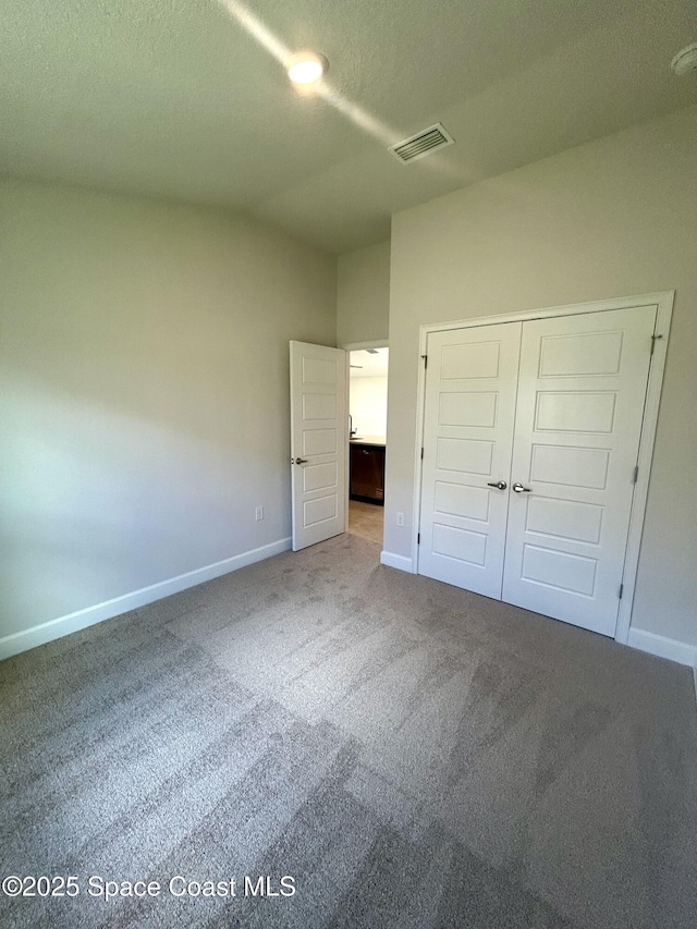1208 Soleway Ave NW, Palm Bay, FL 32907 - unfurnished bedroom with carpet flooring, a closet, and a textured ceiling