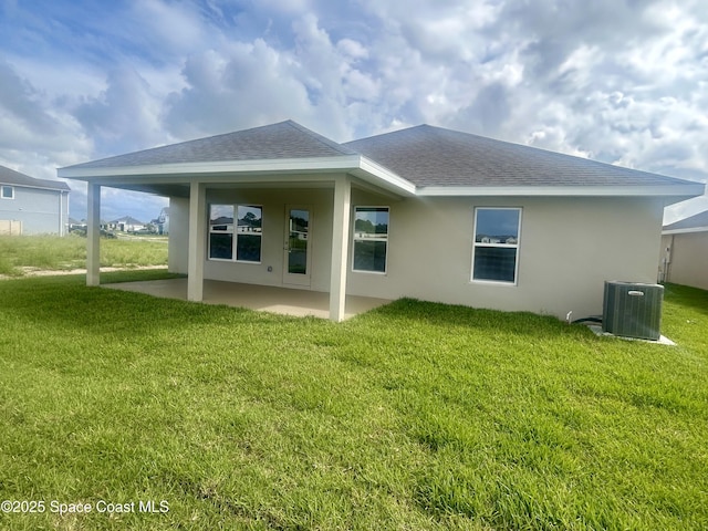 1208 Soleway Ave NW, Palm Bay, FL 32907 - back of house featuring a shingled roof, a patio, stucco siding, and a lawn