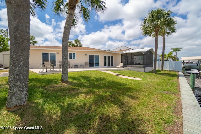 630 Paula Ave, Merritt Island, FL 32953 - back of house with a sunroom, stucco siding, and a patio area