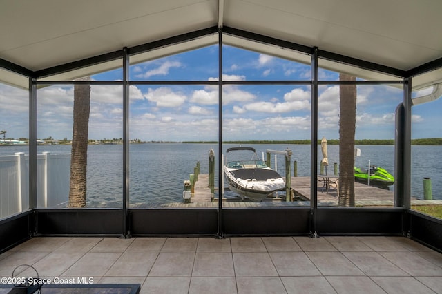 630 Paula Ave, Merritt Island, FL 32953 - unfurnished sunroom with a water view, vaulted ceiling, tile patterned flooring, and a wall of windows