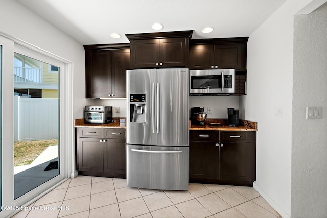 630 Paula Ave, Merritt Island, FL 32953 - kitchen with appliances with stainless steel finishes, light tile patterned floors, dark brown cabinets, stone counters, and recessed lighting