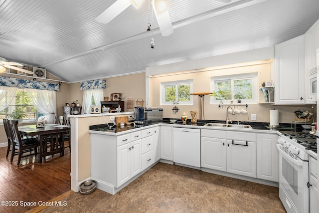kitchen featuring ceiling fan, a sink, a peninsula, white appliances, and white cabinetry
