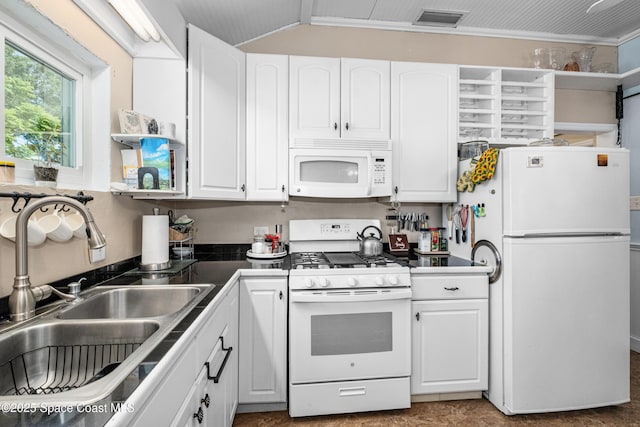 kitchen with visible vents, dark countertops, a sink, white appliances, and white cabinetry