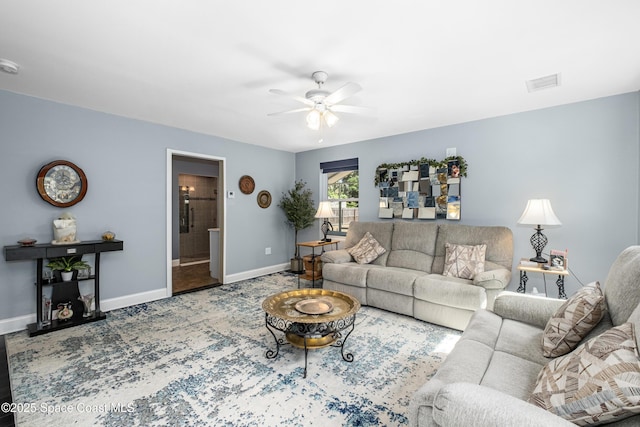 living room featuring baseboards, ceiling fan, and visible vents