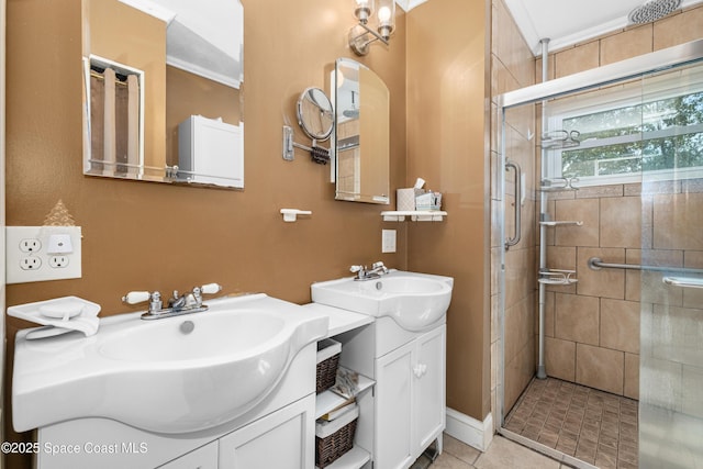 bathroom featuring a sink, two vanities, ornamental molding, and a shower stall