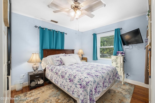 bedroom with baseboards, wood finished floors, and visible vents