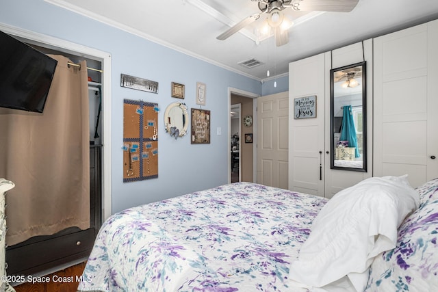 bedroom featuring crown molding, a ceiling fan, wood finished floors, and visible vents