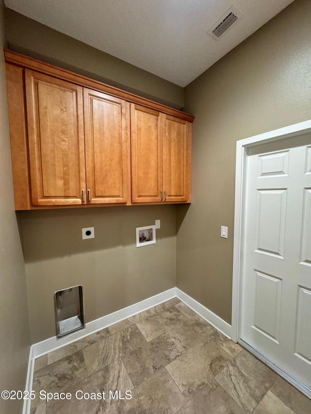laundry area with hookup for an electric dryer, cabinet space, baseboards, visible vents, and washer hookup