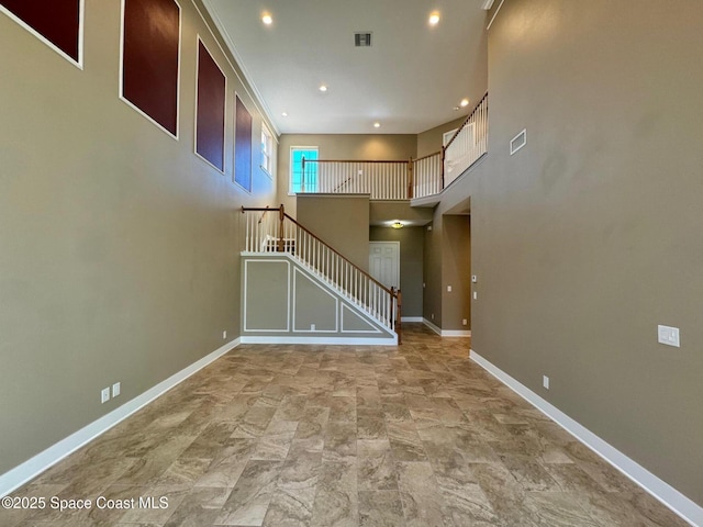 unfurnished living room featuring baseboards, stairs, visible vents, and recessed lighting