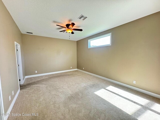 carpeted empty room with baseboards, visible vents, a textured ceiling, and ceiling fan