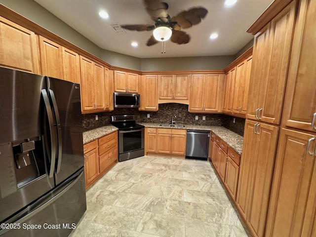 kitchen featuring a sink, ceiling fan, stainless steel appliances, stone counters, and visible vents