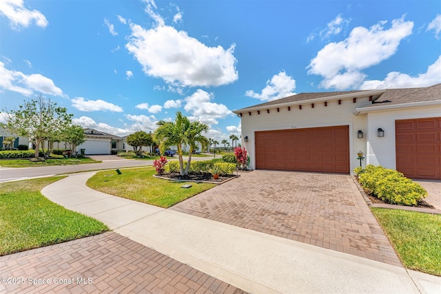 view of front of property with an attached garage, a front lawn, decorative driveway, and stucco siding