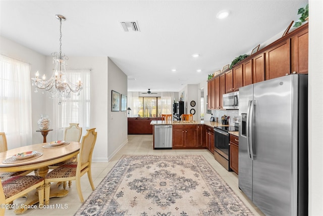 kitchen with a chandelier, stainless steel appliances, light tile patterned floors, visible vents, and a peninsula