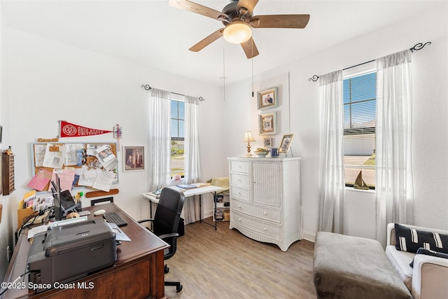 office space with a ceiling fan, light wood finished floors, and baseboards