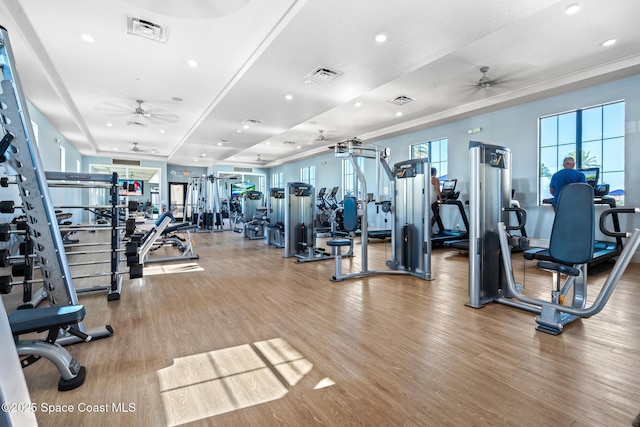 gym featuring wood finished floors, ceiling fan, and visible vents
