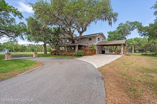 800 Hidden Oaks Ln, Oak Hill, FL 32759 - view of front facade with driveway, stone siding, a front yard, and stucco siding
