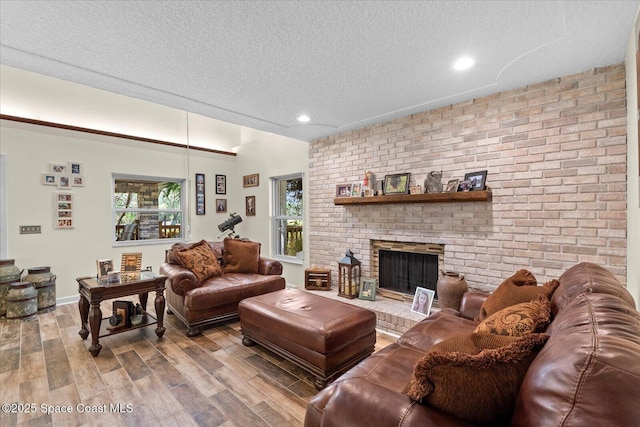 800 Hidden Oaks Ln, Oak Hill, FL 32759 - living area featuring a brick fireplace, wood finished floors, a textured ceiling, and recessed lighting