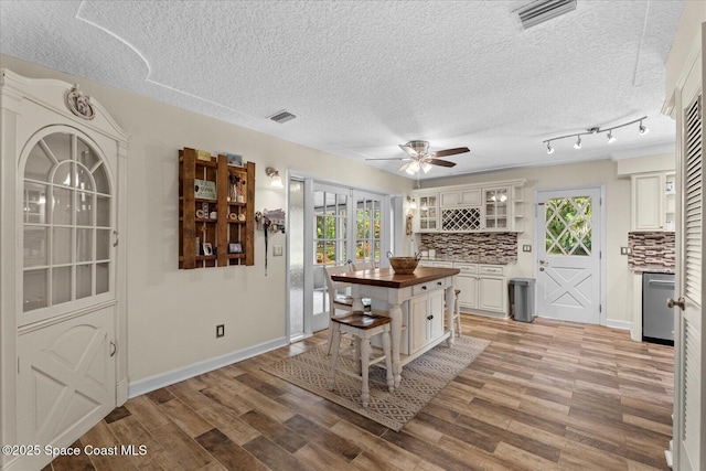 800 Hidden Oaks Ln, Oak Hill, FL 32759 - kitchen with light wood finished floors, butcher block counters, visible vents, and backsplash