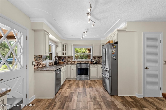 800 Hidden Oaks Ln, Oak Hill, FL 32759 - kitchen with track lighting, backsplash, wood finished floors, and stainless steel appliances