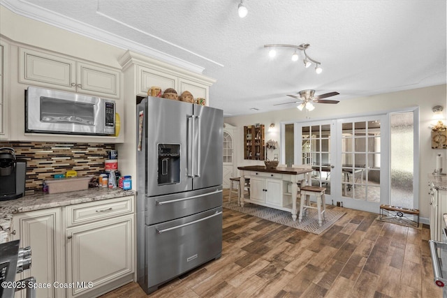 800 Hidden Oaks Ln, Oak Hill, FL 32759 - kitchen with french doors, tasteful backsplash, appliances with stainless steel finishes, and cream cabinets