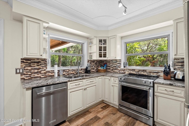 800 Hidden Oaks Ln, Oak Hill, FL 32759 - kitchen with light wood finished floors, stainless steel appliances, open shelves, a sink, and crown molding