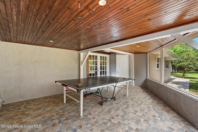 800 Hidden Oaks Ln, Oak Hill, FL 32759 - rec room with stone flooring, a textured wall, wooden ceiling, and french doors