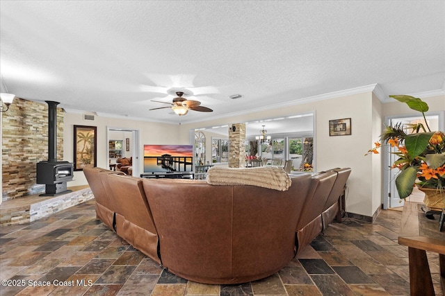 800 Hidden Oaks Ln, Oak Hill, FL 32759 - living room with a ceiling fan, a textured ceiling, stone tile flooring, a wood stove, and ornamental molding