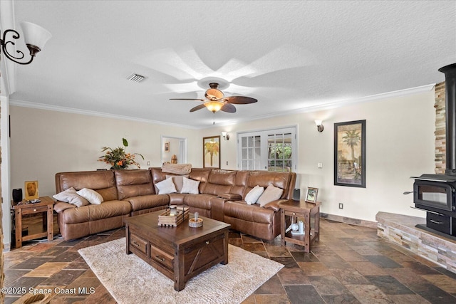 800 Hidden Oaks Ln, Oak Hill, FL 32759 - living room featuring ceiling fan, ornamental molding, a wood stove, and visible vents