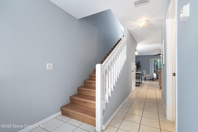 staircase with tile patterned flooring, baseboards, and ceiling fan