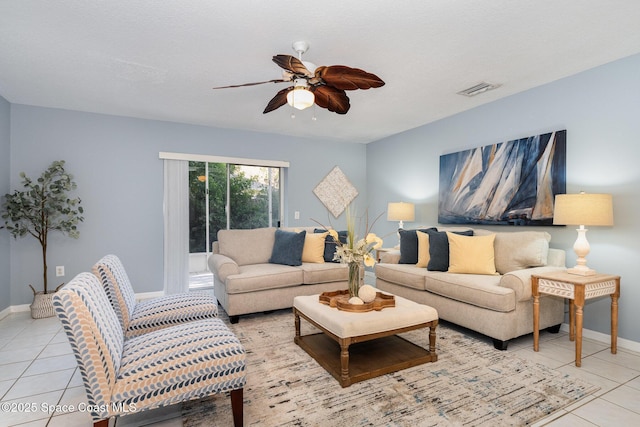 tiled living room with ceiling fan and baseboards