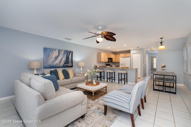 living room featuring light tile patterned floors, a ceiling fan, baseboards, and recessed lighting