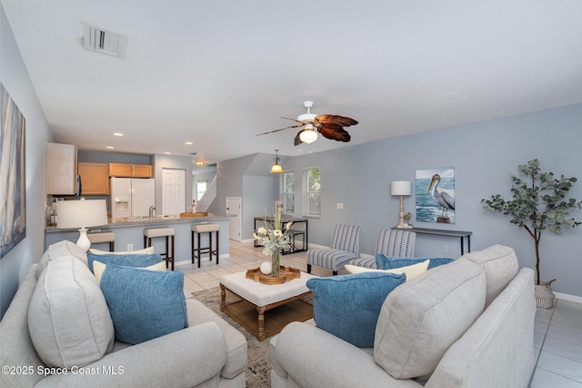living area with light tile patterned floors, ceiling fan, baseboards, and recessed lighting