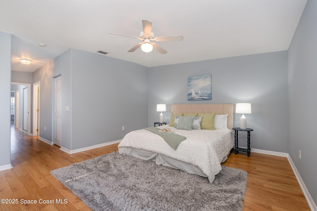 bedroom featuring light wood-style flooring, baseboards, and a ceiling fan