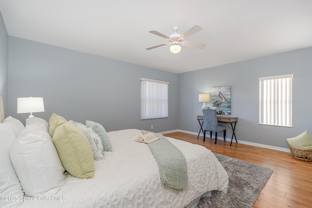 bedroom featuring wood finished floors, baseboards, and ceiling fan