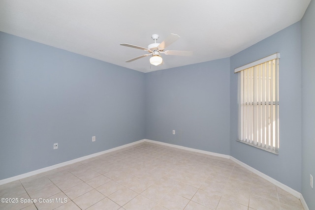 spare room featuring ceiling fan and baseboards