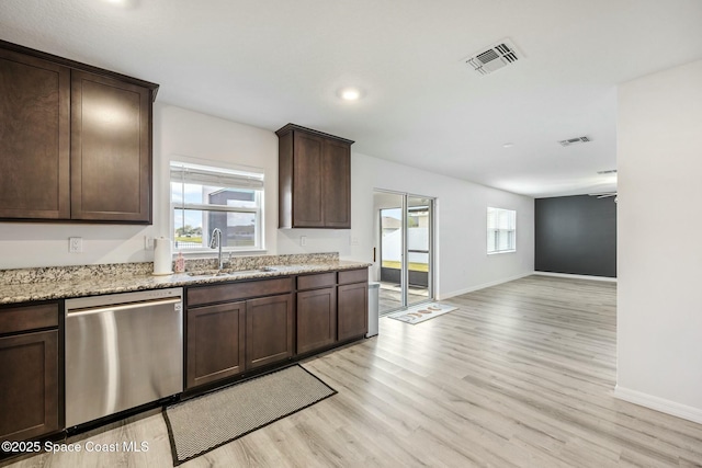 kitchen with dishwasher, light wood finished floors, a sink, and visible vents