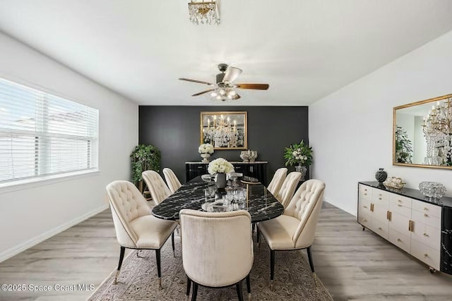 dining area with light wood finished floors, baseboards, and a ceiling fan